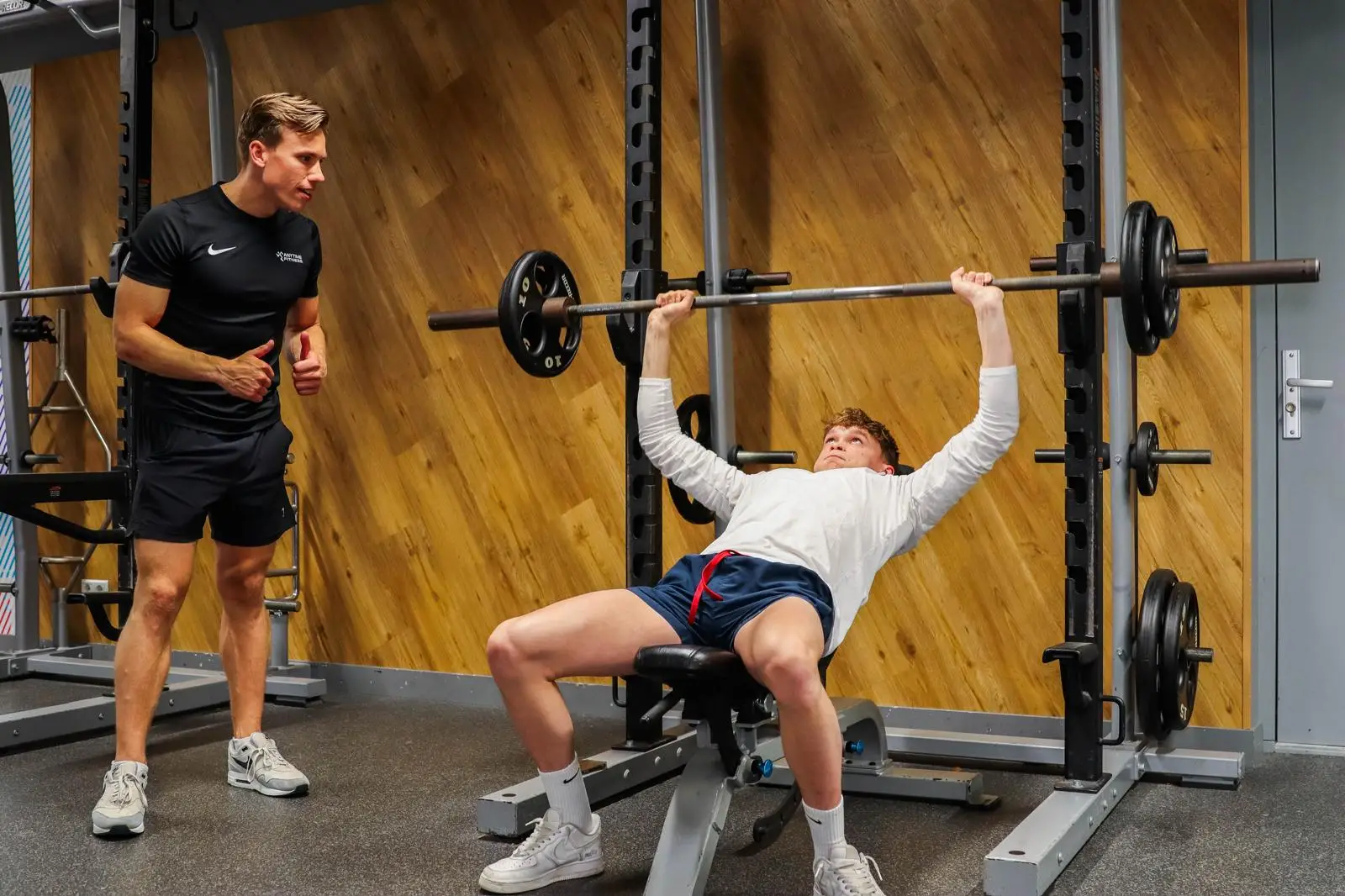 Olivier begeleidt een sporter bij een oefening.