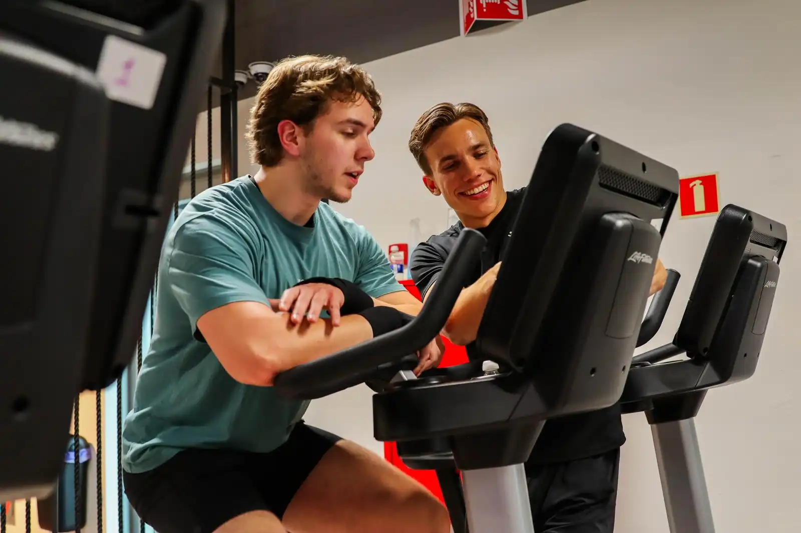 Olivier begeleidt een sporter bij een oefening.
